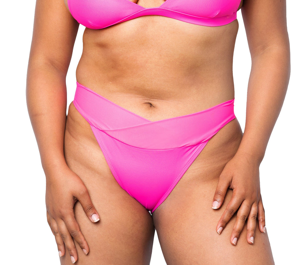 Model wearing MIGA Ally Bikini Bottom with Crossover Waistband in Neon Pink. Wearing matching MIGA Ally Bikini Top.