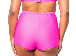 Model looking back wearing MIGA Ally Boy Shorts in Neon Pink with matching MIGA Ally Bikini Top.