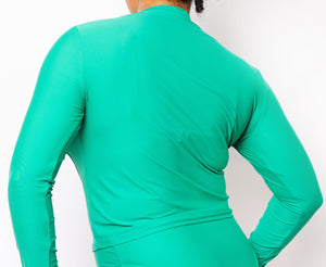 Model looking back wearing Spiral Swim Shirt in Emerald Green with matching Colette bikini bottom in Emerald Green.