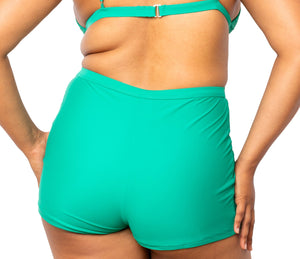Model looking back wearing MIGA Ally Boy Shorts in Emerald Green with matching MIGA Ally Bikini Top.