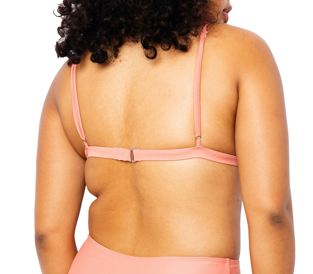 Model facing back wearing MIGA Ally Bikini Top in Rose with Adjustable Straps and matching MIGA Colette Bikini Bottom in Rose.