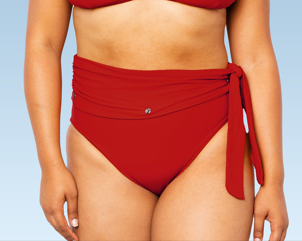 Model wearing Lydia maternity high-waisted bikini bottom with snap belt and matching Ally Bikini Bottom in red.