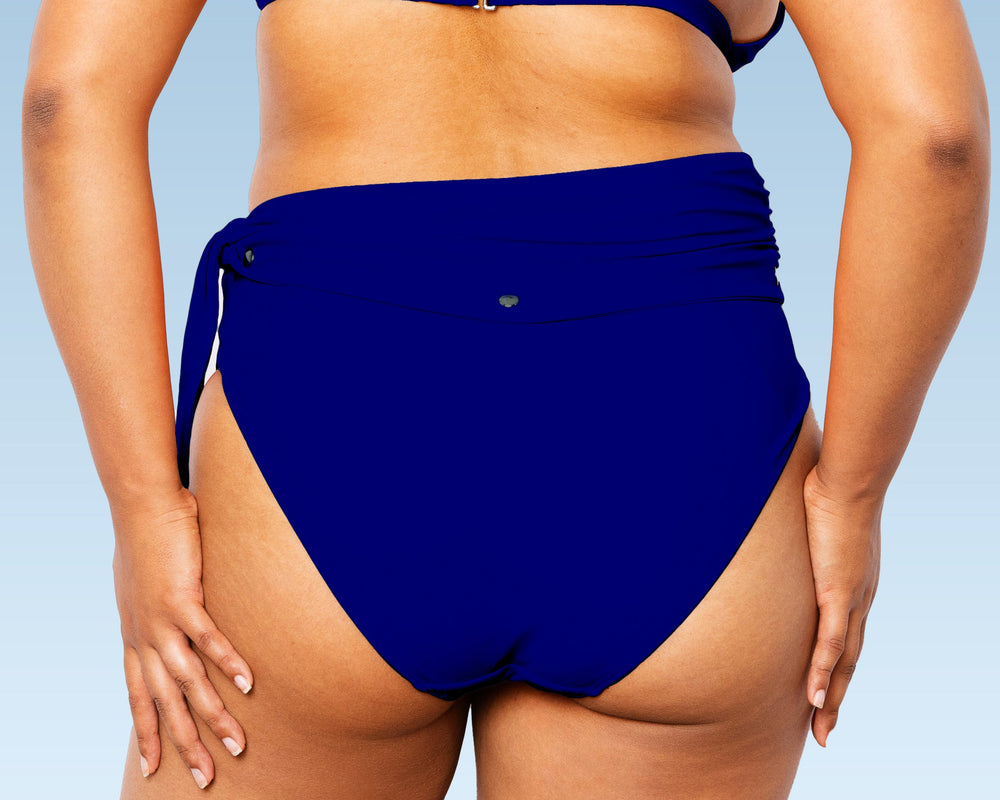 Model from back wearing Lydia maternity high-waisted bikini bottom with snap belt and matching Ally Bikini Bottom in navy blue.