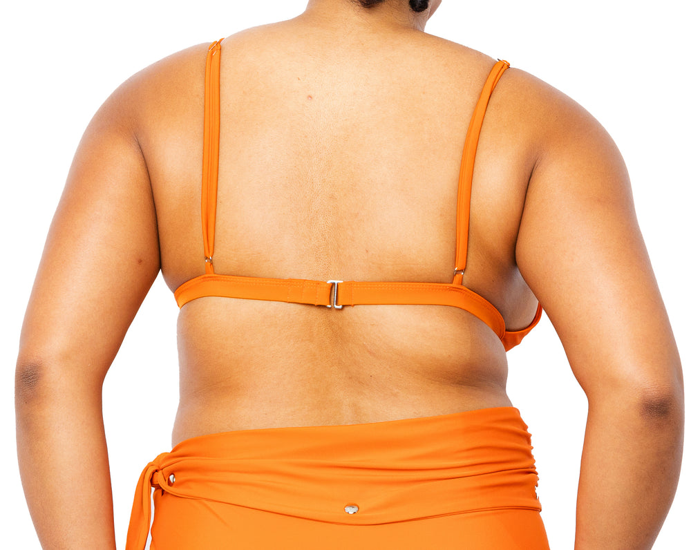 Model facing back wearing MIGA Ally Bikini Top in Burnt Orange with Adjustable Straps and Lydia Bikini Bottom.